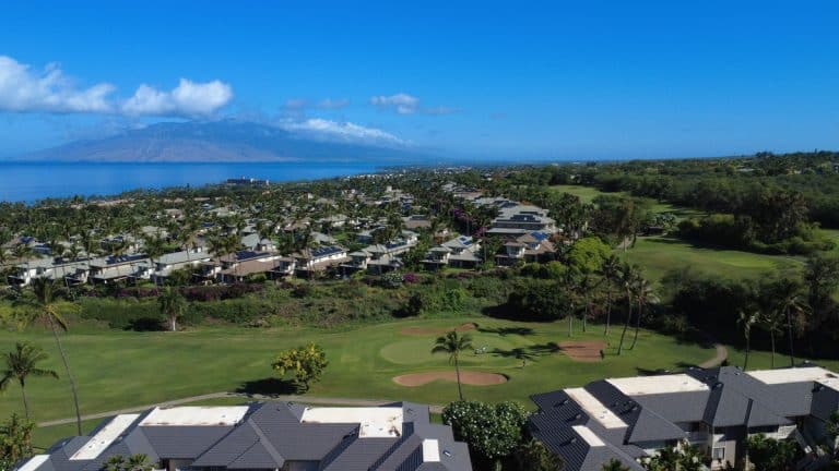 Aerial view over Grand Champions Villas and the Wailea Blue course toward the ocean and West Maui