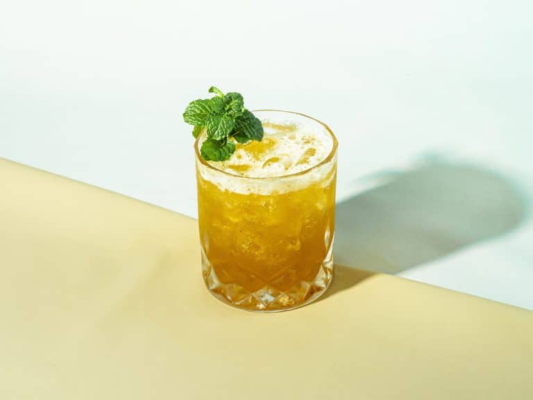 Mai tai cocktail over crushed ice with a mint sprig garnish