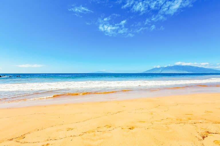 Bright sunny day on a golden sand beach in South Maui with clear blue sky