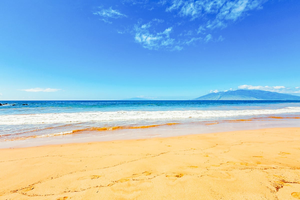 Bright sunny day on a golden sand beach in South Maui with clear blue sky