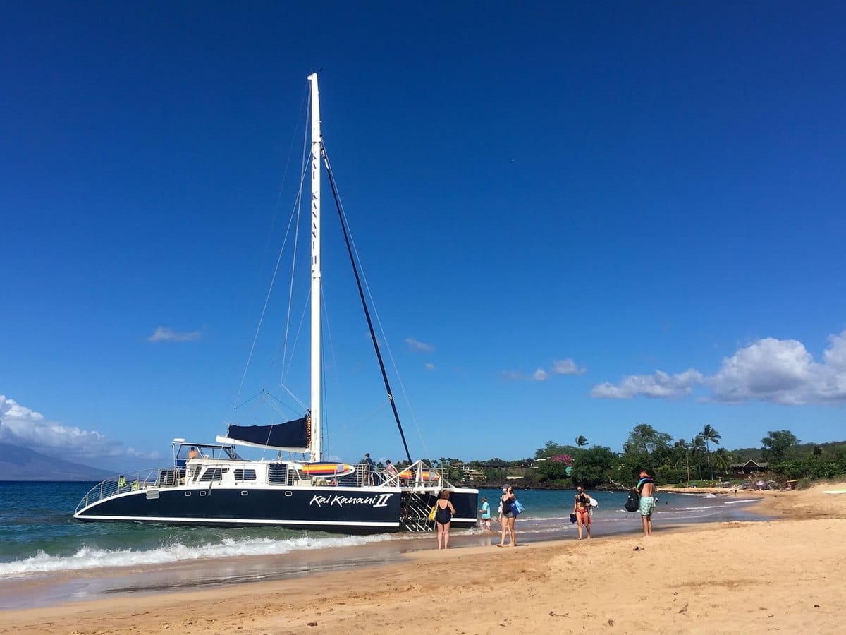 Snorkel catamaran pulled up on a sandy Maui beach