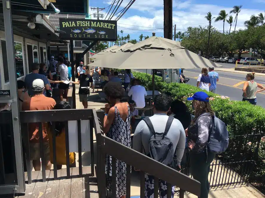 People lined up outside Paia Fish Market South Side in Kihei, Maui, under its sign