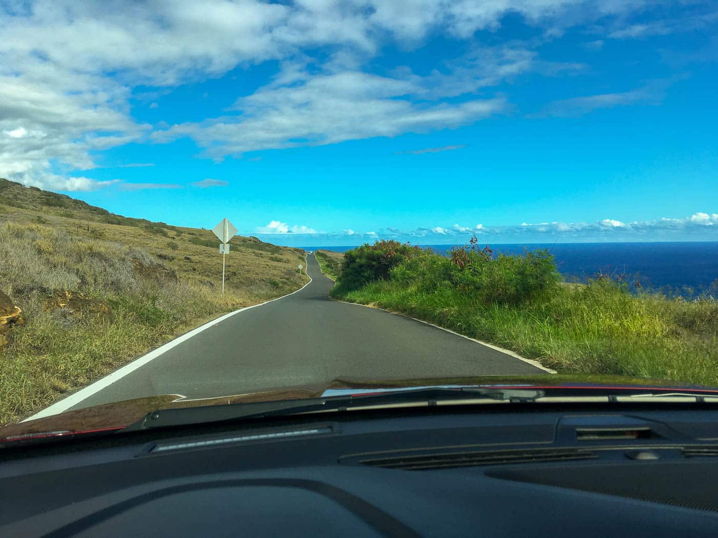 Driving the back side of the Road to Hana past dry hills and the ocean near Kaupo