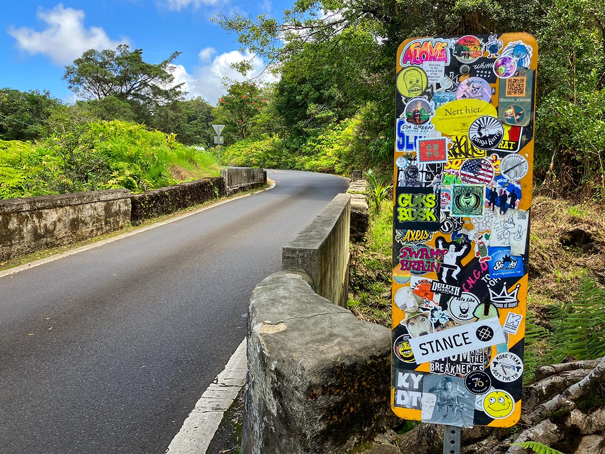 One-lane bridge on the Road to Hana with a sticker-covered sign